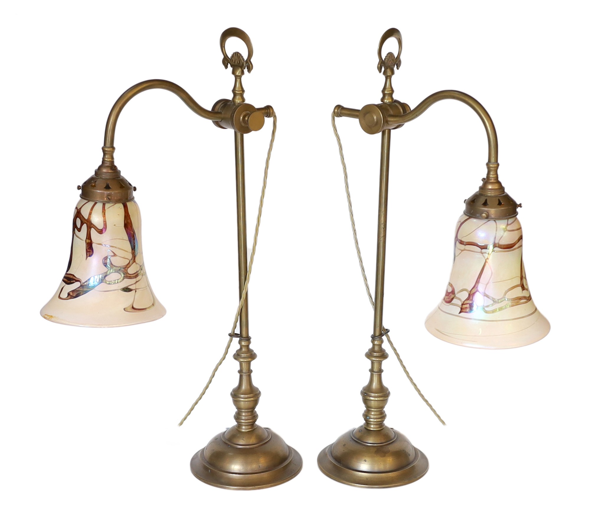 A pair of Edwardian style brass desk lamps with loetz style glass shades, height 61cm